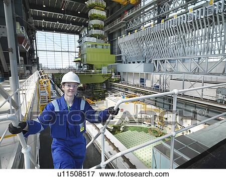Stock Photo - Apprentice engineer in Charging Hall. Fotosearch