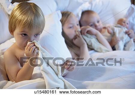 Babies in bed with their blankets View Large Photo Image Stock Image - Babies in bed with their blankets. Fotosearch