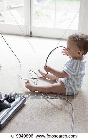 Baby on floor playing with hoover cable View Large Photo Image Stock Photograph - Baby on floor playing with hoover cable. Fotosearch