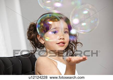 Beautiful girl trying catch soap bubbles View Large Photo Image Stock Photo - Beautiful girl trying catch soap bubbles. Fotosearch