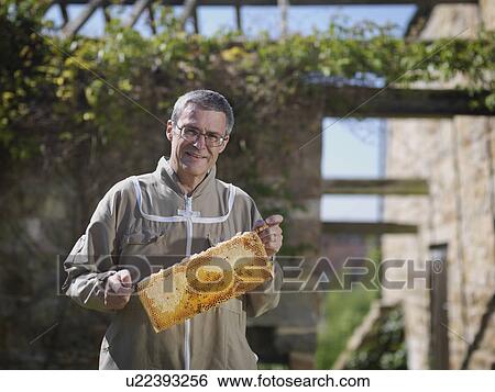 Beekeeper with honey comb View Large Photo Image Stock Photograph - Beekeeper with honey comb. Fotosearch