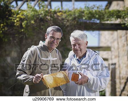 Beekeepers with honey comb and honey View Large Photo Image Stock Photo - Beekeepers with honey comb and honey. Fotosearch