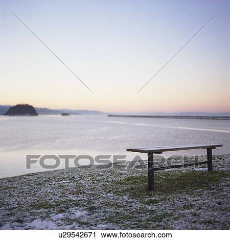 Stock Image - Bench by sea, wintertime. Fotosearch