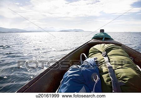 Stock Photo - Bow of wooden boat with rucksacks. Fotosearch