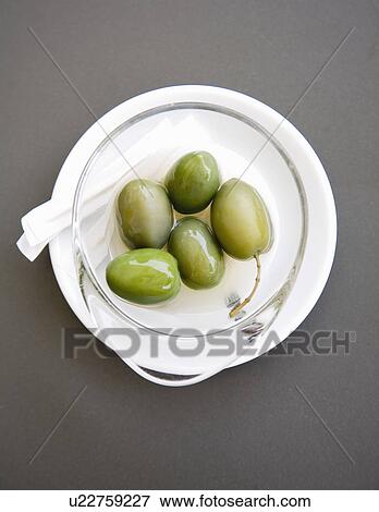 Bowl of green olives on table View Large Photo Image Stock Photo - Bowl of green olives on table. Fotosearch
