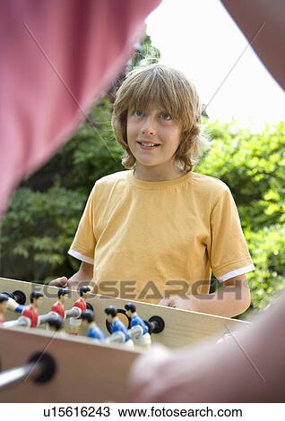 Boy (10-12) playing table football View Large Photo Image Stock Image - Boy (10-12) playing table football. Fotosearch