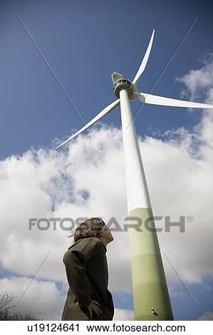 Boy (8-9) looking up at wind turbine View Large Photo Image Stock Image - Boy (8-9) looking up at wind turbine. Fotosearch