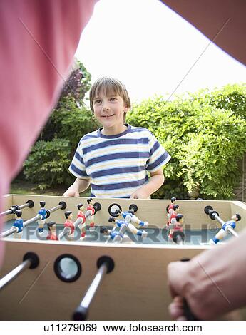 Boy (8-9) playing table football View Large Photo Image Stock Photo - Boy (8-9) playing table football. Fotosearch