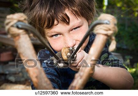 Boy aiming catapult View Large Photo Image Stock Image - Boy aiming catapult. Fotosearch