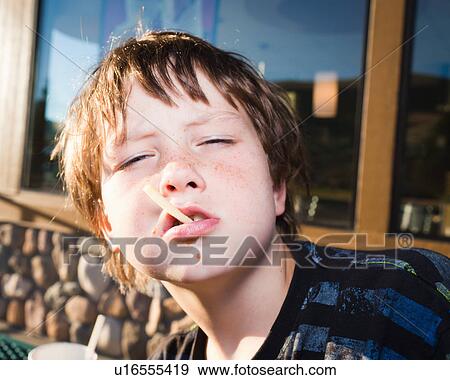 Boy being defiant with junk food View Large Photo Image Stock Photo - Boy being defiant with junk food. Fotosearch