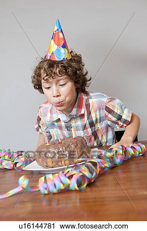 Boy blowing out birthday candle View Large Photo Image Stock Image - Boy blowing out birthday candle. Fotosearch