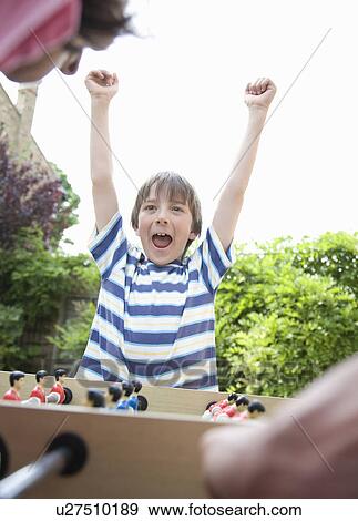 Boy celebrating, playing table football View Large Photo Image Stock Photo - Boy celebrating, playing table football. Fotosearch