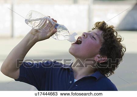 Boy drinking water from a bottle View Large Photo Image Stock Image - Boy drinking water from a bottle. Fotosearch