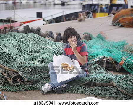 Boy eating fish and chips in harbour View Large Photo Image Stock Image - Boy eating fish and chips in harbour. Fotosearch