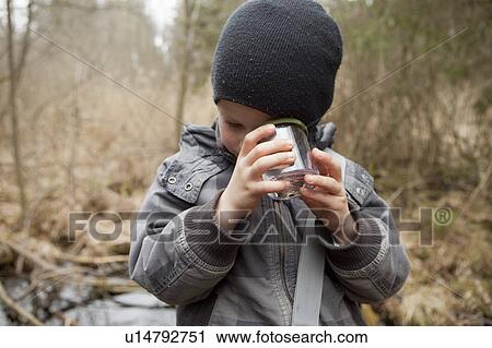 Stock Image - Boy examining something in a glass. Fotosearch