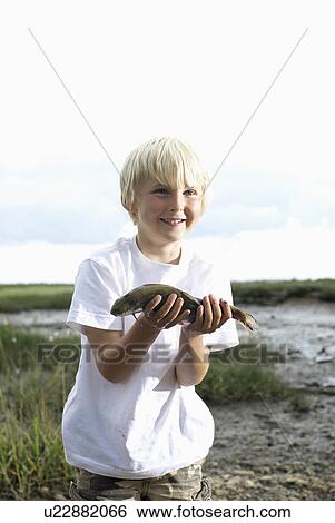 Boy holding fish up View Large Photo Image Stock Photograph - Boy holding fish up. Fotosearch