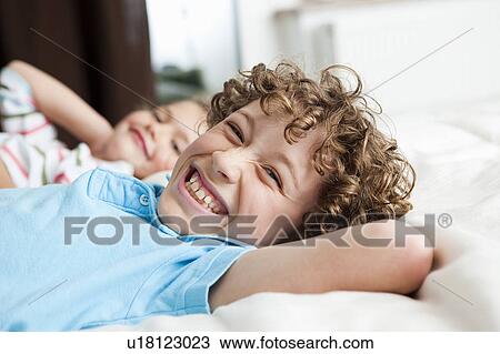 Boy in bed smiling View Large Photo Image Stock Image - Boy in bed smiling. Fotosearch