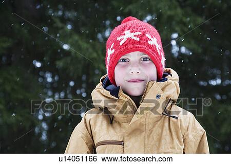 Stock Photograph - Boy in wooly hat with snow flakes. Fotosearch