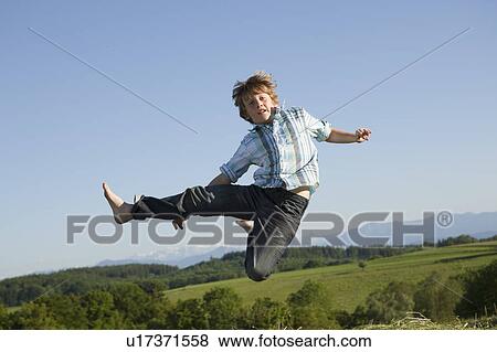 Boy jumping in air View Large Photo Image Stock Photo - Boy jumping in air. Fotosearch