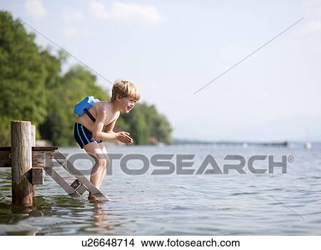 Boy jumping in water with swimming belt View Large Photo Image Picture - Boy jumping in water with swimming belt. Fotosearch