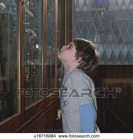 Boy looking at glass cabinets View Large Photo Image Picture - Boy looking at glass cabinets. Fotosearch
