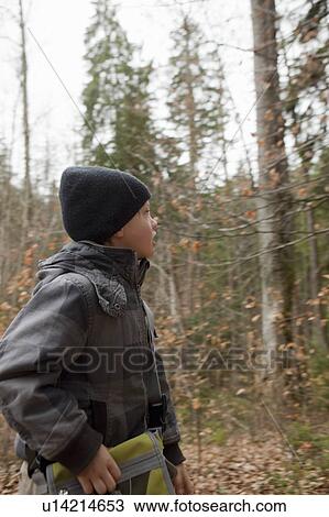 Boy looking for something in a forest View Large Photo Image Stock Image - Boy looking for something in a forest. Fotosearch