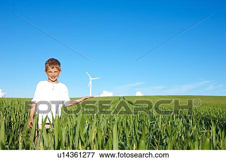 Boy on field with wind turbine View Large Photo Image Stock Photo - Boy on field with wind turbine. Fotosearch