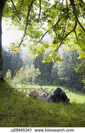 Boy playing with a limb under a tree View Large Photo Image Stock Image - Boy playing with a limb under a tree. Fotosearch