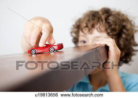 Stock Photograph - Boy playing with small red car. Fotosearch