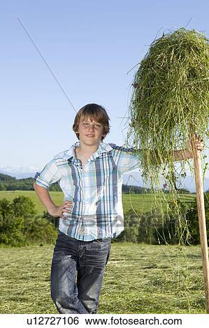 Boy resting on hayfork, proud View Large Photo Image Stock Photograph - Boy resting on hayfork, proud. Fotosearch