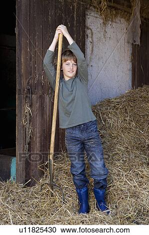 Boy resting on hayfork View Large Photo Image Stock Image - Boy resting on hayfork. Fotosearch
