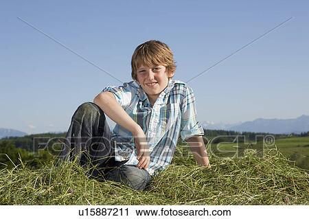Stock Image - Boy sitting in grass. Fotosearch