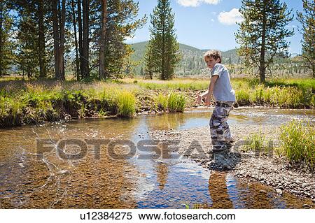 Stock Photography - Boy skimming stones. Fotosearch