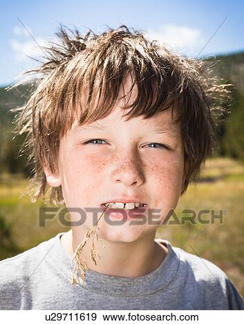 Boy Smiling whilst chewing grass View Large Photo Image Stock Photo - Boy Smiling whilst chewing grass. Fotosearch