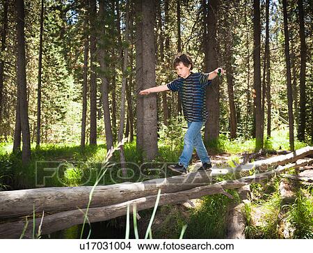Picture - Boy walking across log. Fotosearch
