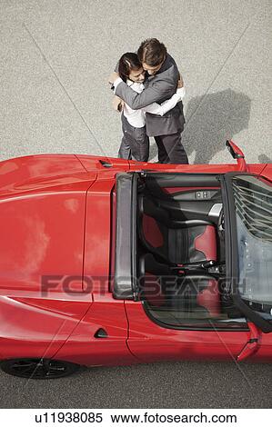 Business couple huging near electric car View Large Photo Image Stock Photography - Business couple huging near electric car. Fotosearch