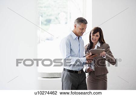 Business couple looking at clipboard View Large Photo Image Stock Image - Business couple looking at clipboard. Fotosearch