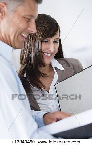 Stock Image - Business couple looking at file. Fotosearch