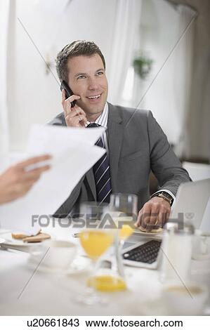 Stock Image - Business man having breakfast. Fotosearch