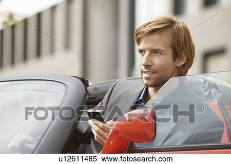 Business man on phone in an electric car View Large Photo Image Stock Photography - Business man on phone in an electric car. Fotosearch