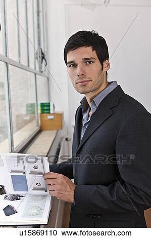 Business man reviewing a catalogue View Large Photo Image Stock Image - Business man reviewing a catalogue. Fotosearch