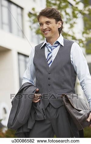 Business man smiling, jacket in hand View Large Photo Image Stock Image - Business man smiling, jacket in hand. Fotosearch
