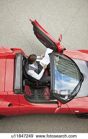 Business man working near electric car View Large Photo Image Stock Photo - Business man working near electric car. Fotosearch