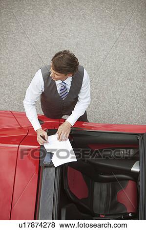 Business man working near electric car View Large Photo Image Stock Photo - Business man working near electric car. Fotosearch