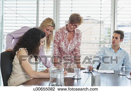 Business people looking at paperwork View Large Photo Image Stock Image - Business people looking at paperwork. Fotosearch