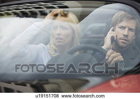 Business people sitting in electric car View Large Photo Image Stock Photo - Business people sitting in electric car. Fotosearch