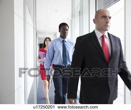 Business people walking down corridor View Large Photo Image Stock Image - Business people walking down corridor. Fotosearch