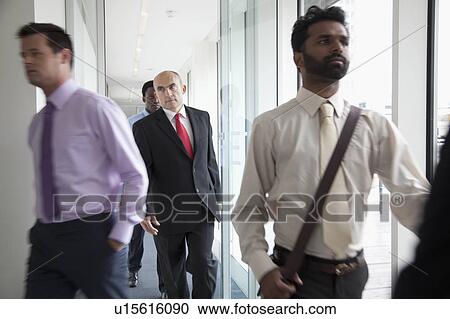 Stock Image - Business people walking fast past camera. Fotosearch