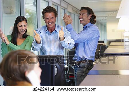 Picture - Business team closing a deal, happy. Fotosearch