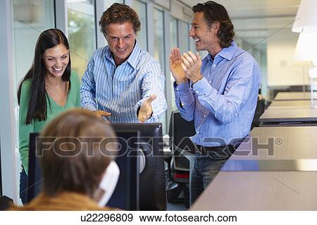 Stock Photo - Business team closing a deal, happy. Fotosearch